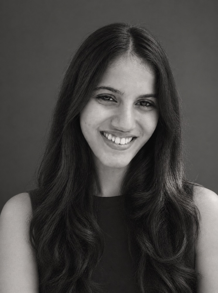 Aditi Vasa, smiling, in a black and white portrait